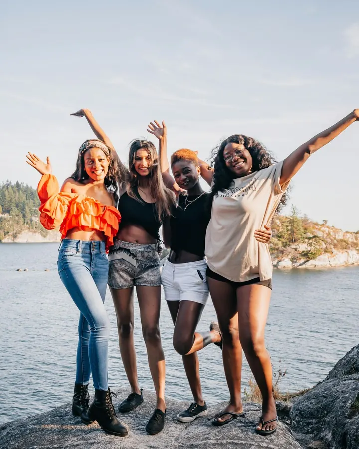 Four friends celebrating on a lakeside trip